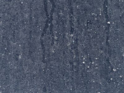 Tan skin shows the cracks, fine lines trace the field, grit holds the shadow