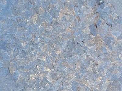 White crystals bloom, sharp edges meet the grey, frozen light holds fast