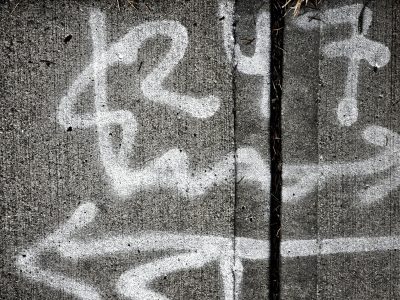 White marks on the grey, chalky lines trace the pavement, grit meets the surface