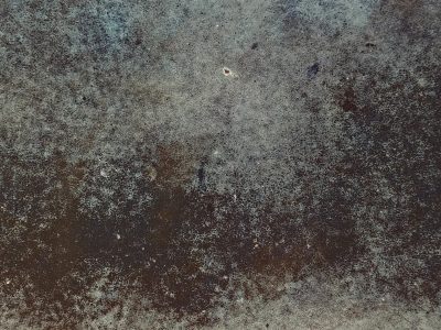 Dark metal surface, rust spreads across the texture, time leaves its cold mark