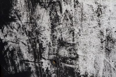 White paint flakes away, black skin waits beneath the cold, grit holds the pattern