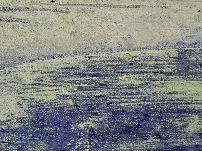 Yellow paint is worn, purple streaks mark the surface, grit meets the pale green