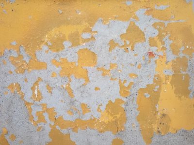 Yellow paint on the barrier, heavy grit meets the concrete, weather marks the line