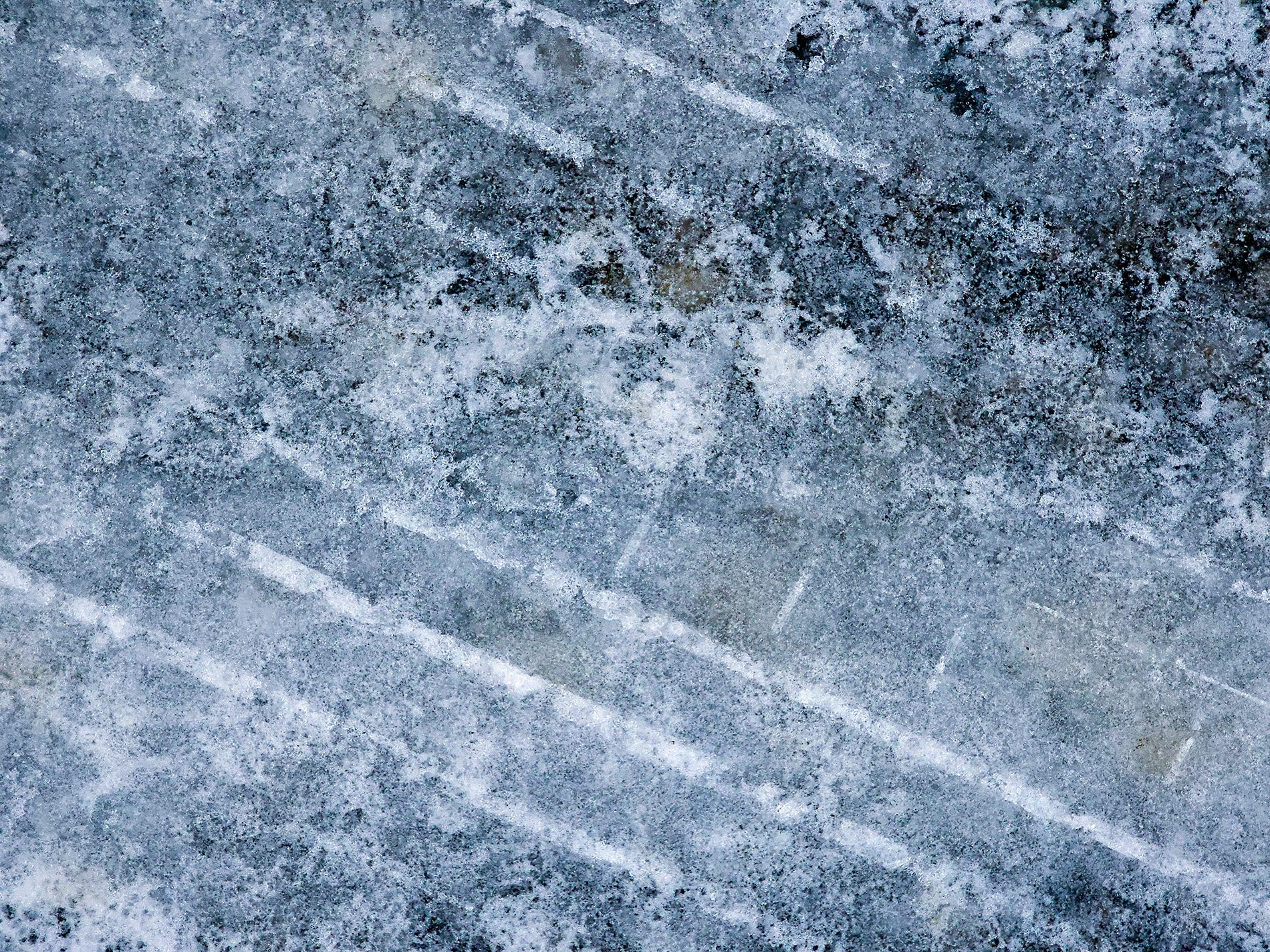 White lines scar the frost, rubber treads on winter blue, time holds every mark.