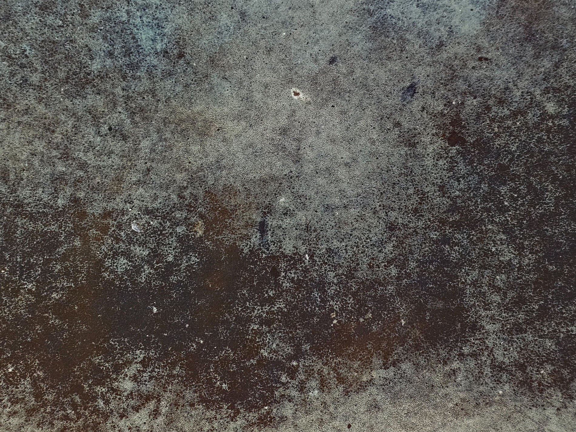 Dark metal surface, rust spreads across the texture, time leaves its cold mark