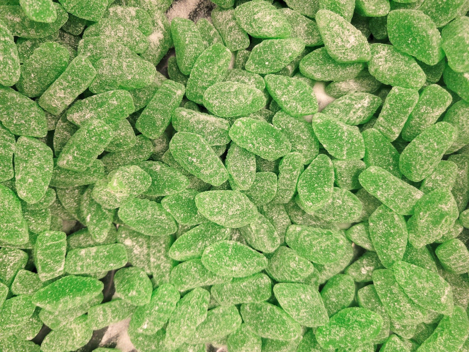 White sugar clogs the grain, yellow depths show beneath, grit marks the clump