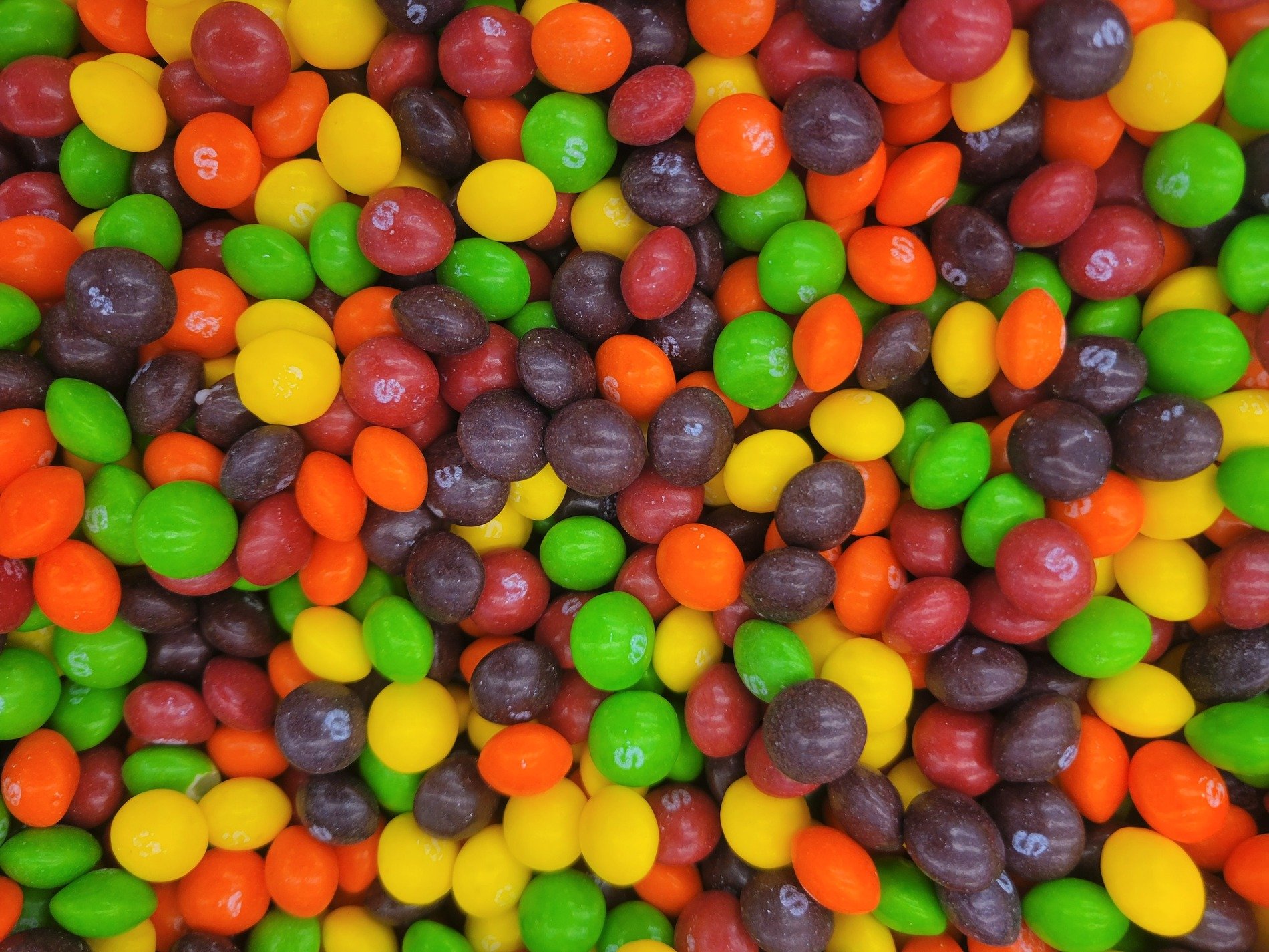 White sugar clogs the grain, yellow depths show beneath, grit marks the organic clump