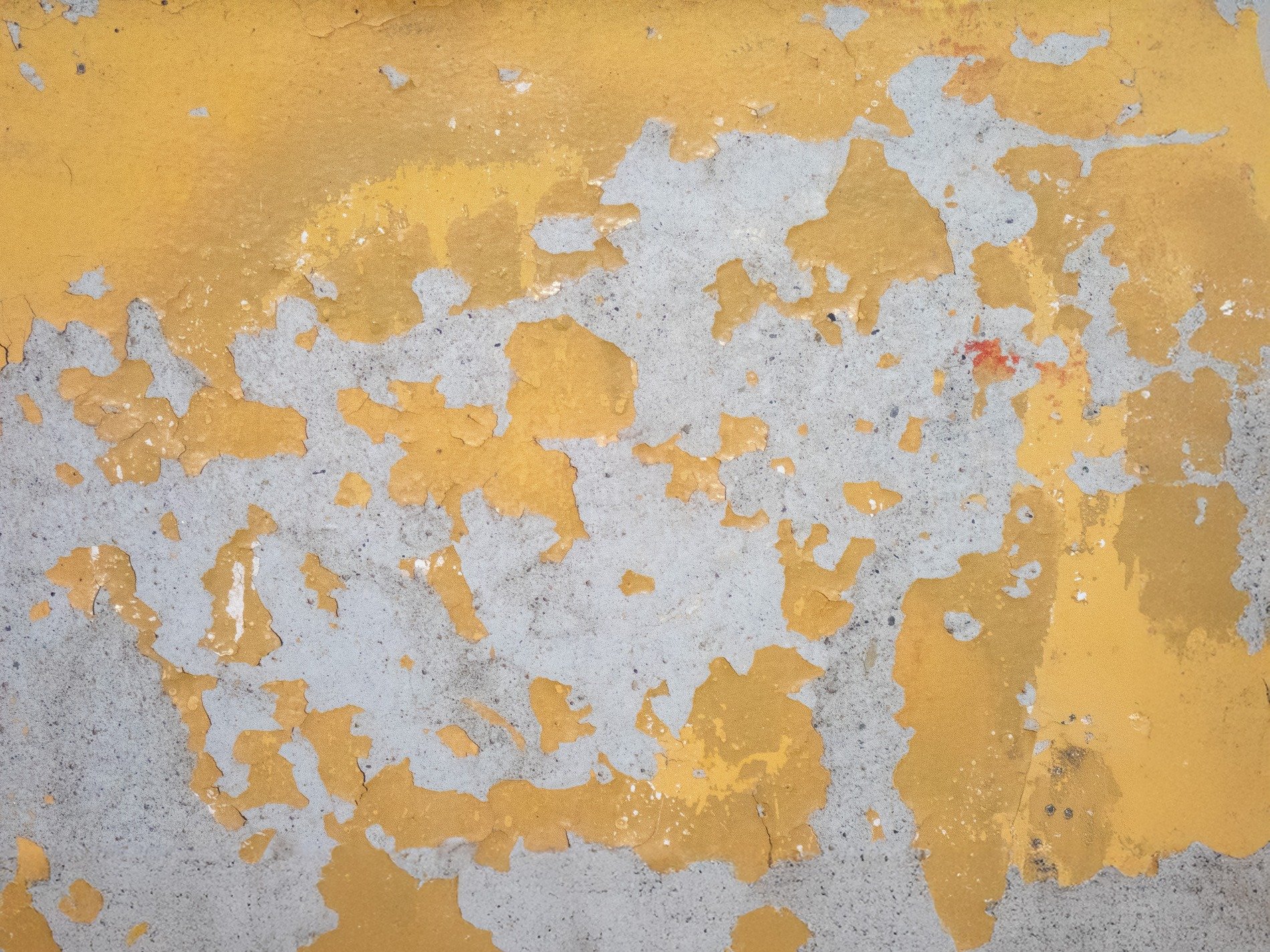 Yellow paint on the barrier, heavy grit meets the concrete, weather marks the line