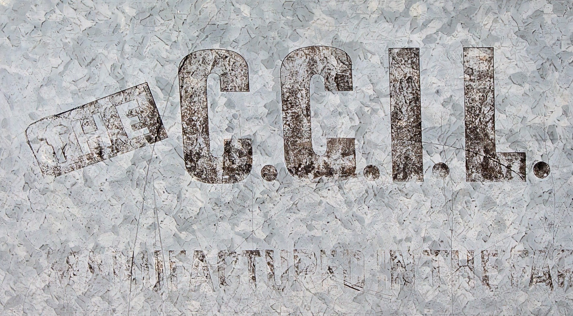 Zinc patterns shimmer, ink marks the weathered surface, iron holds its ground