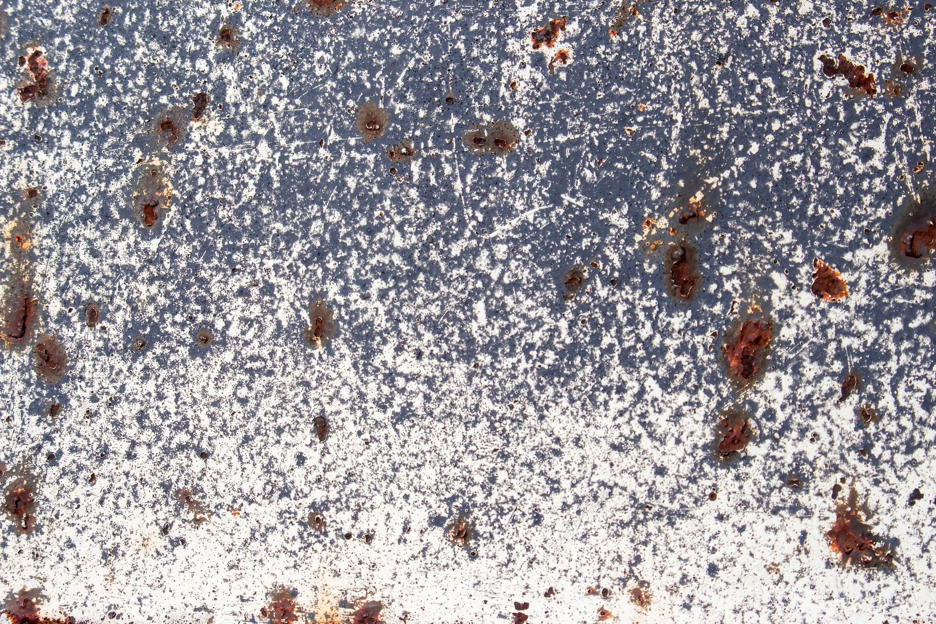 White paint flakes away, dark shadows hide deep within, rust pits cold hard steel