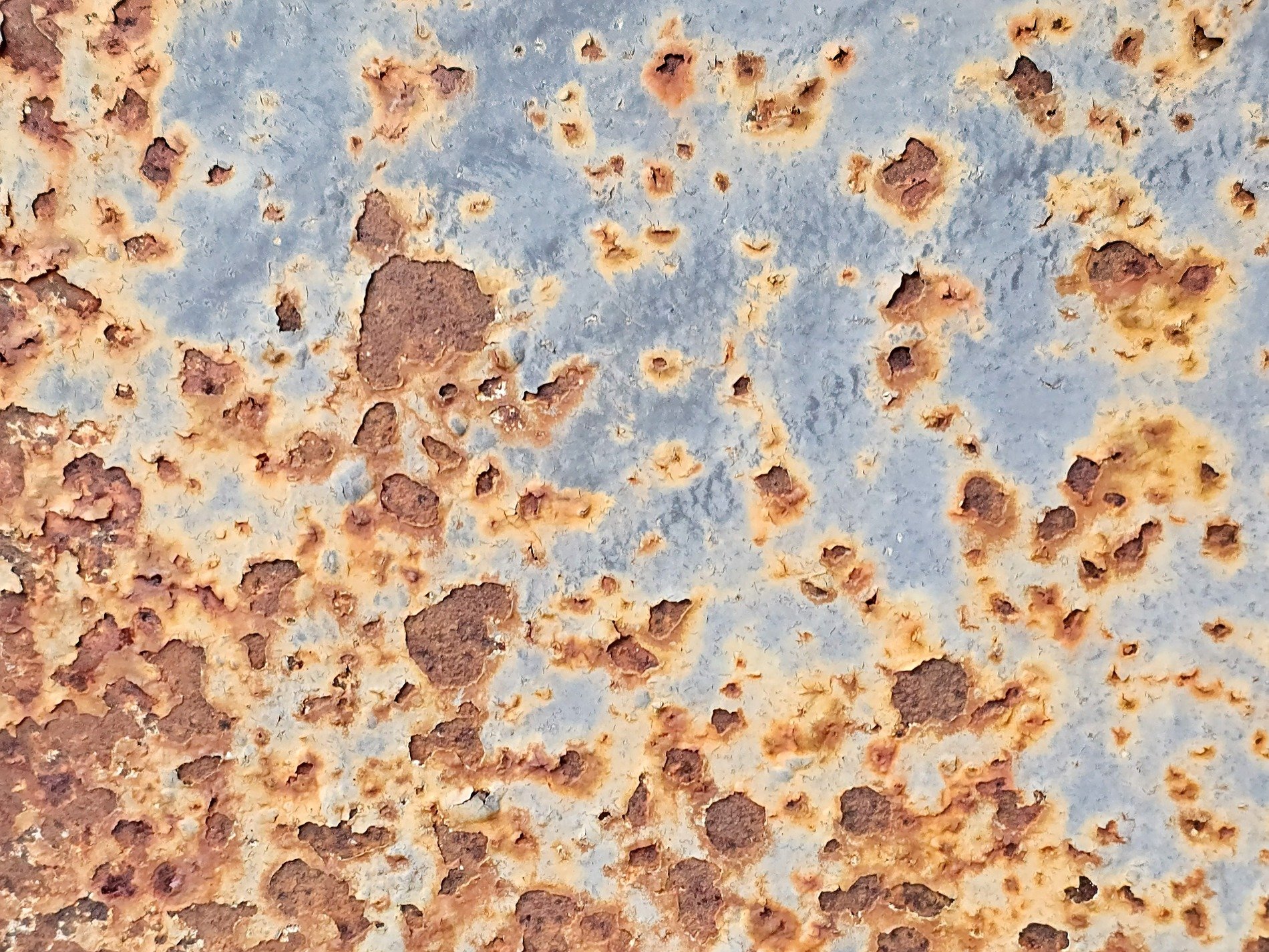 Blue paint flakes away, orange oxidation blooms, iron turns to dust