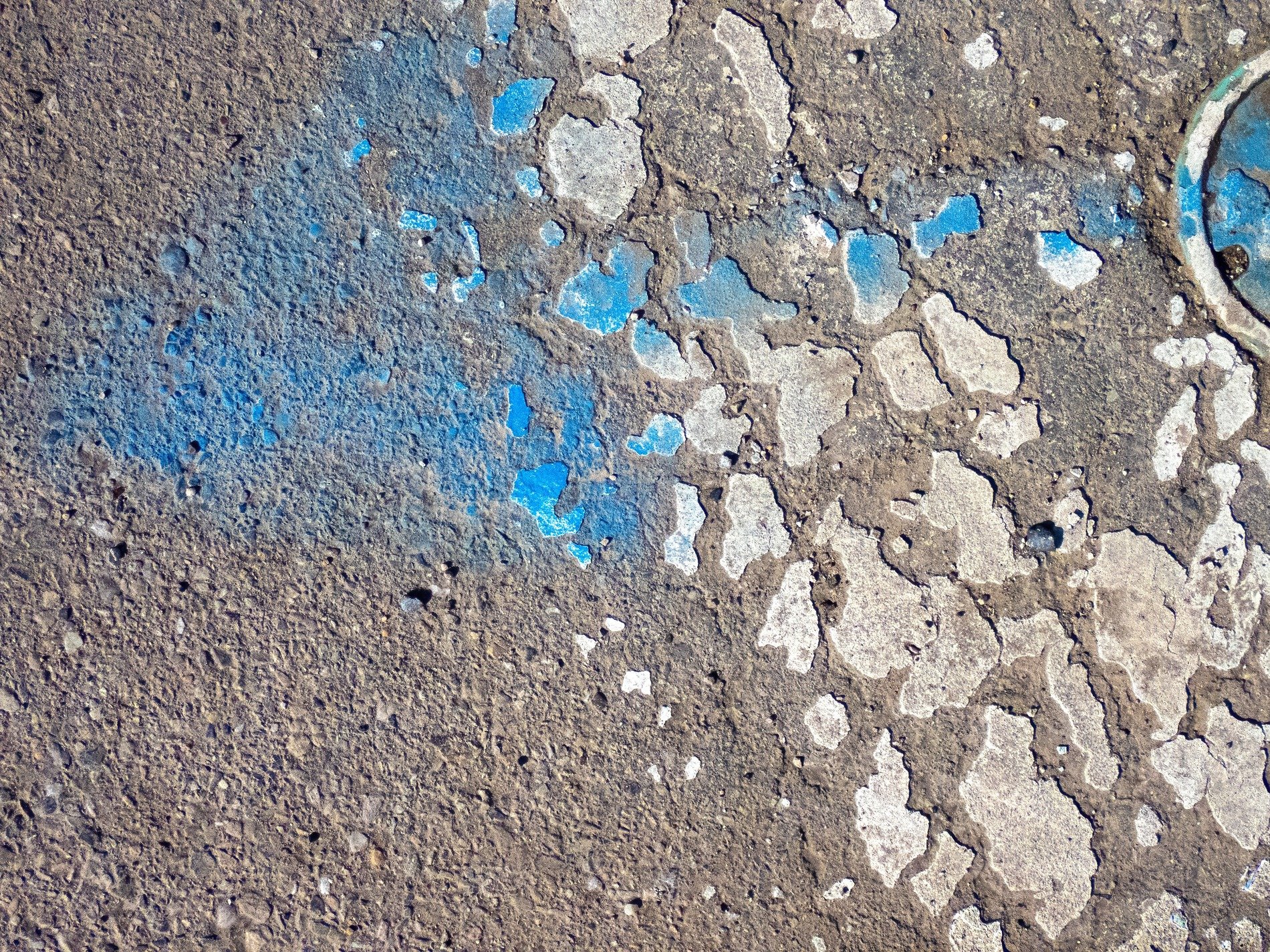 Blue paint peels away, rough grey stone shows through the cracks, grit hides in the gaps