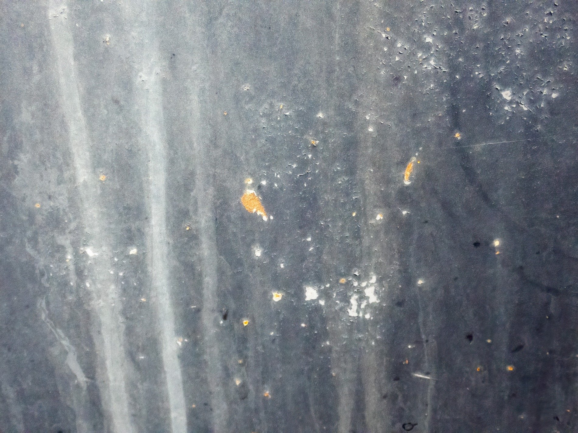 Grey paint starts to flake, streaks of rain wash down the dark, orange rust takes root