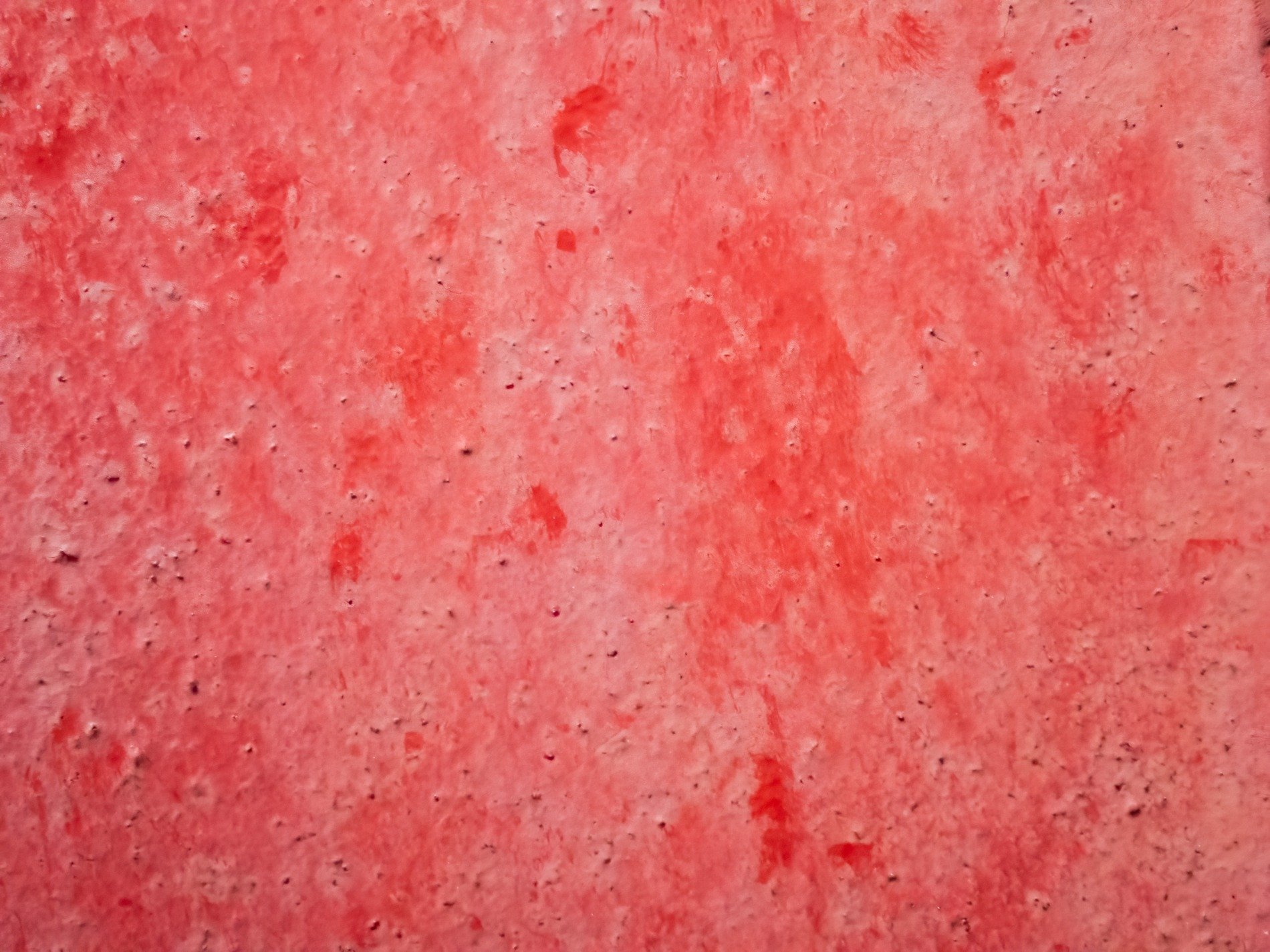 Crimson stains the stone, pitted surface holds the hue, layers wear with time