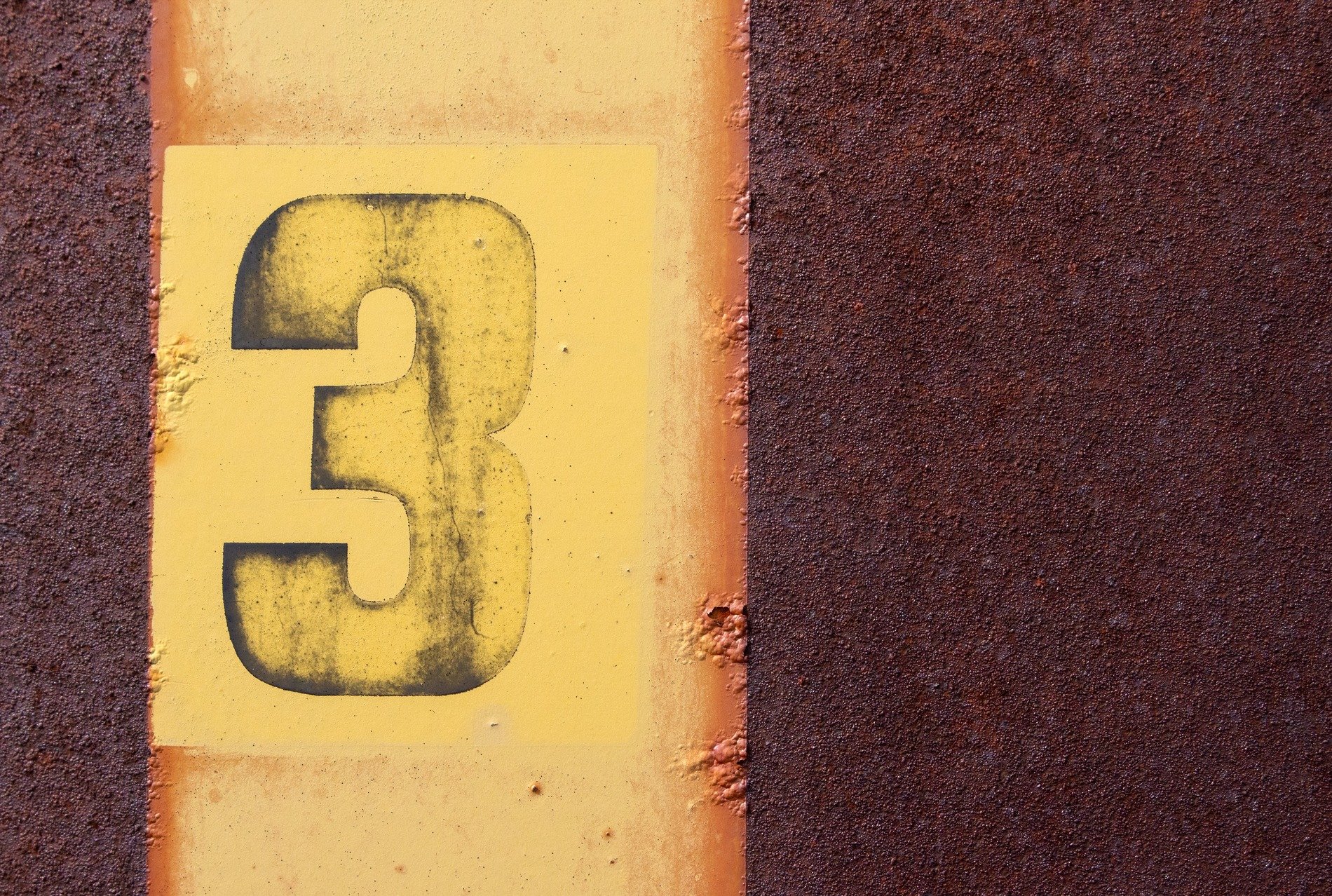 Yellow number three, rust consumes the metal sheet, time marks its decay