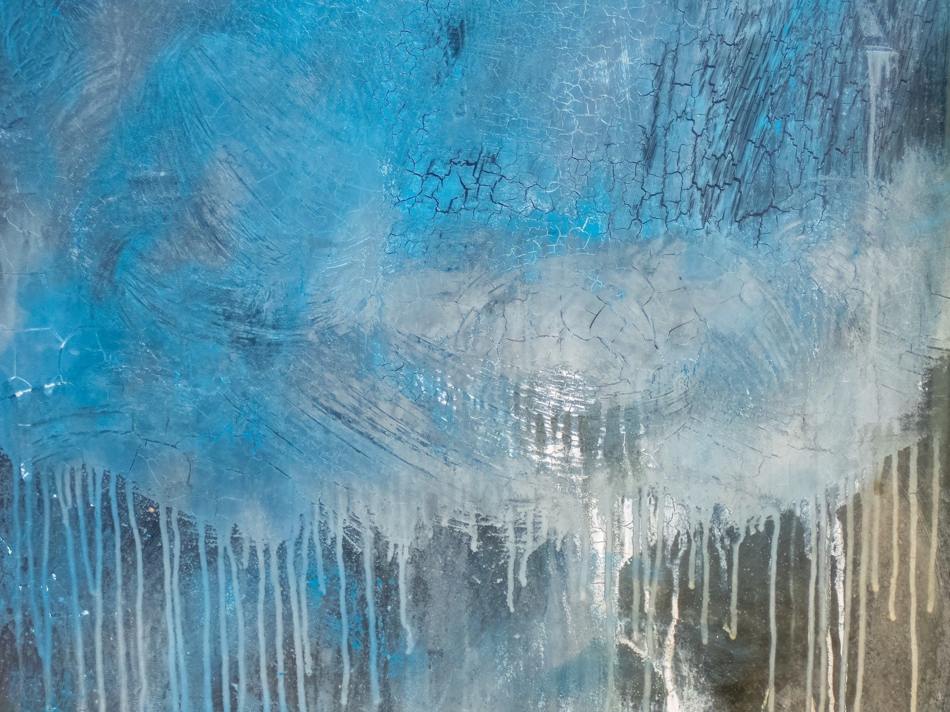 Blue skin hides the pane, jagged marks trace the surface, faint light bleeds through deep