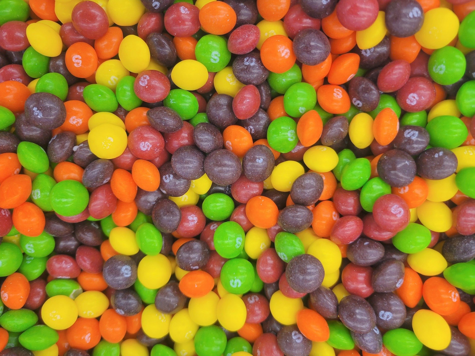 Bright gems made of sweets, rainbow shells piled in a heap, sugar coats the treats