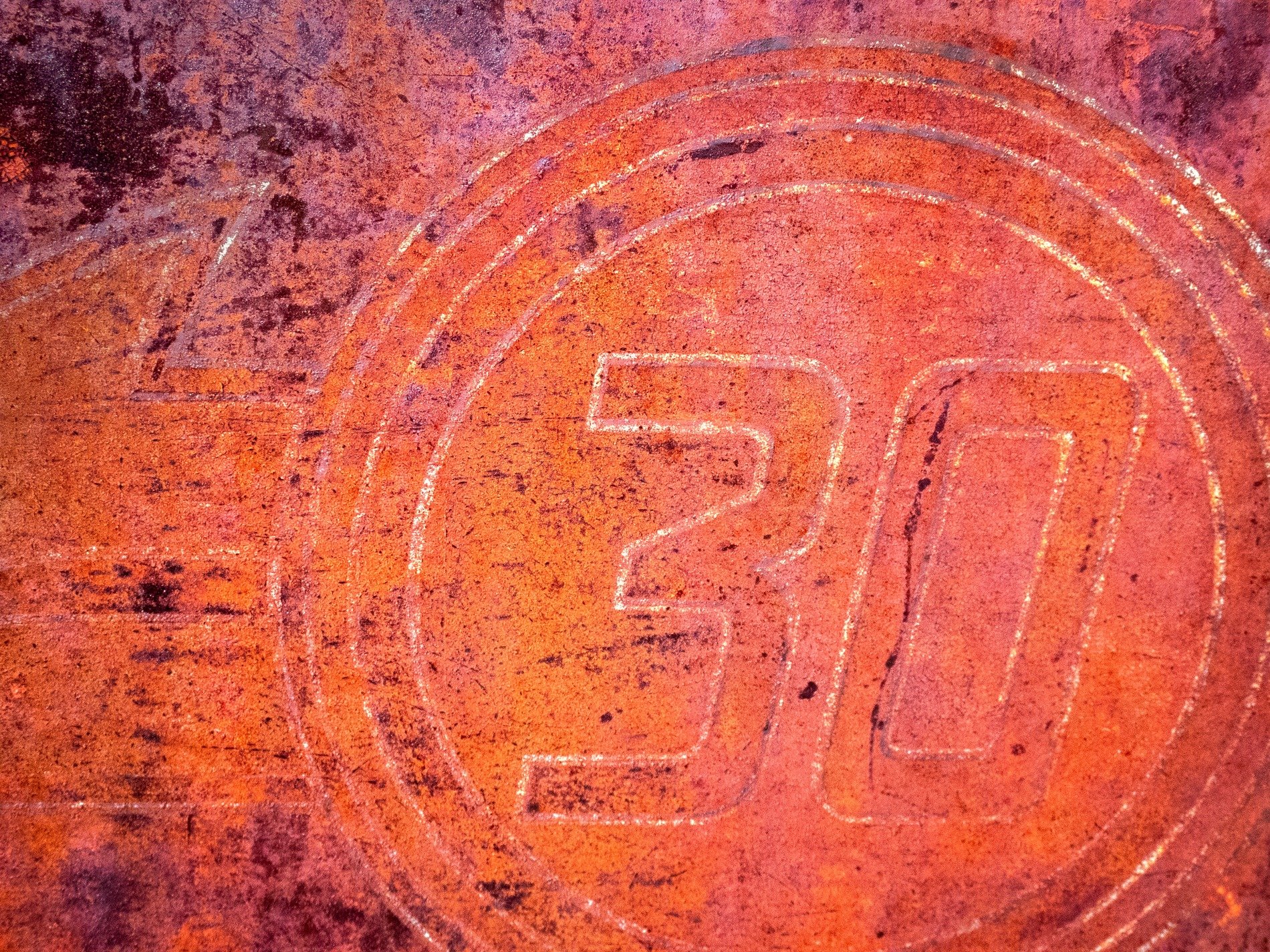 Circular marks meet the grit, heavy rust claims the numbered field, years leave a deep trace