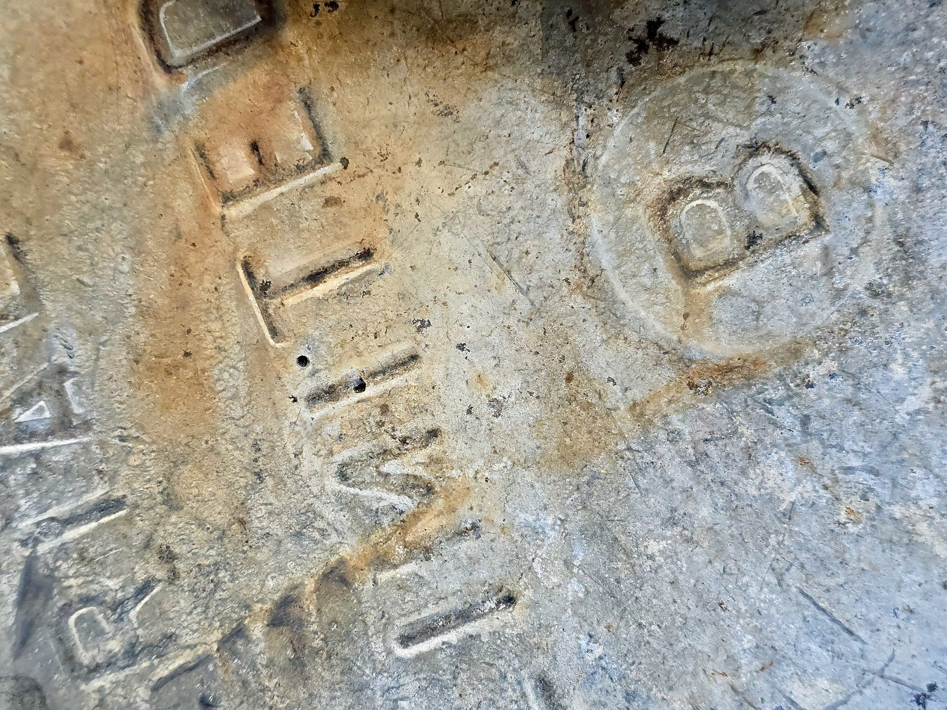 Cold iron surface, rust stains crawl across the steel, words stamped deep in time