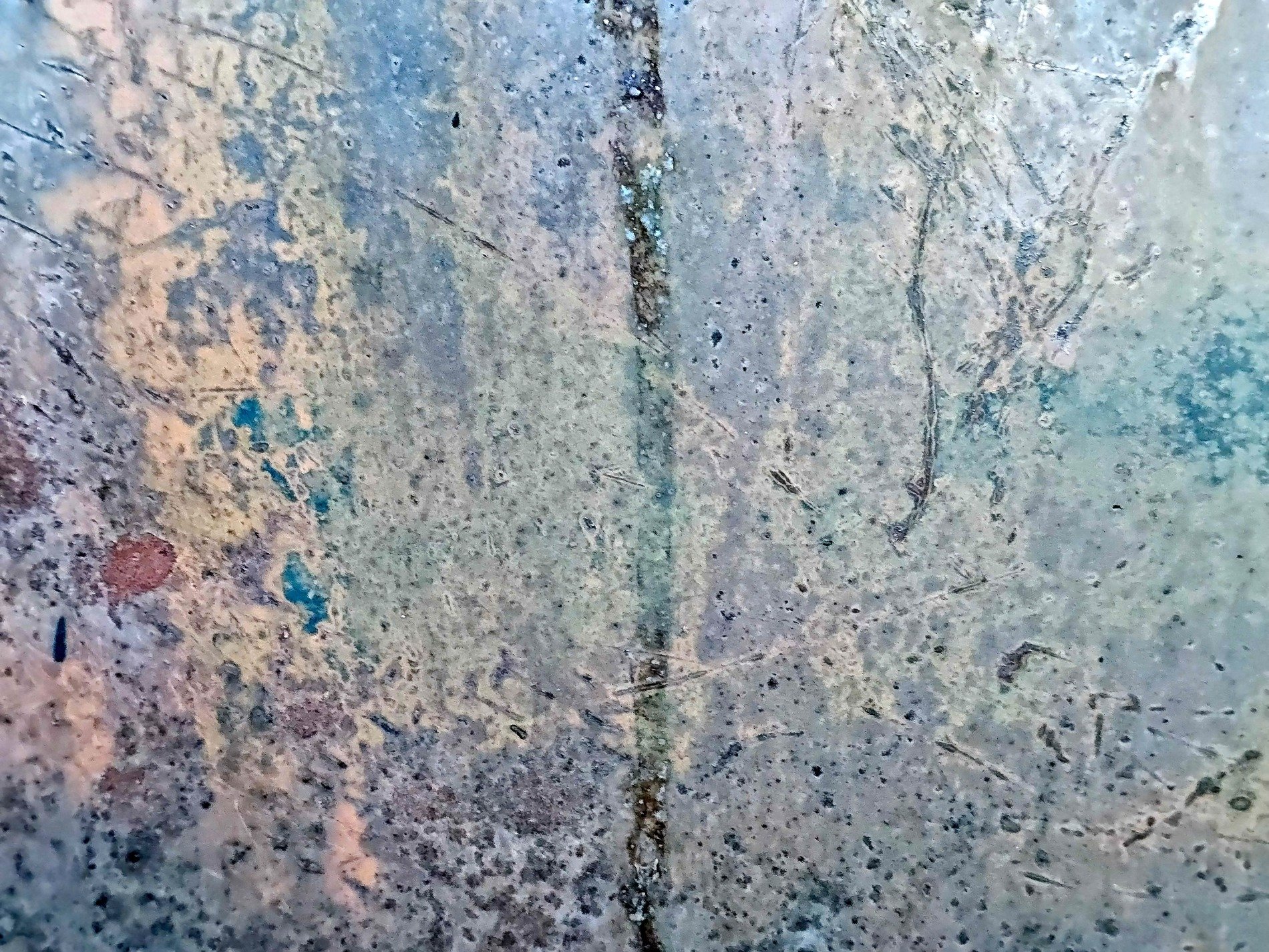 Cold steel bears the scars, blue and grey meet rust and dust, central seam holds fast