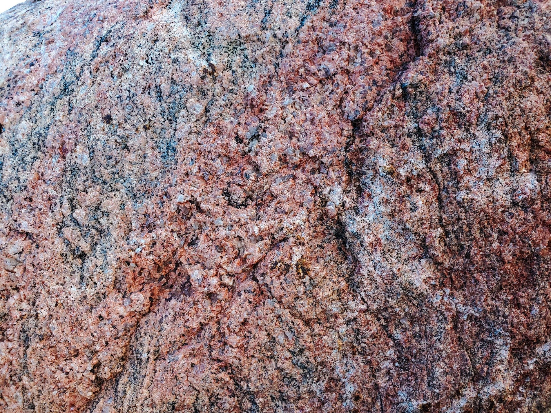 Crimson flecks in stone, crystalline peaks rise and fall, ancient rock remains