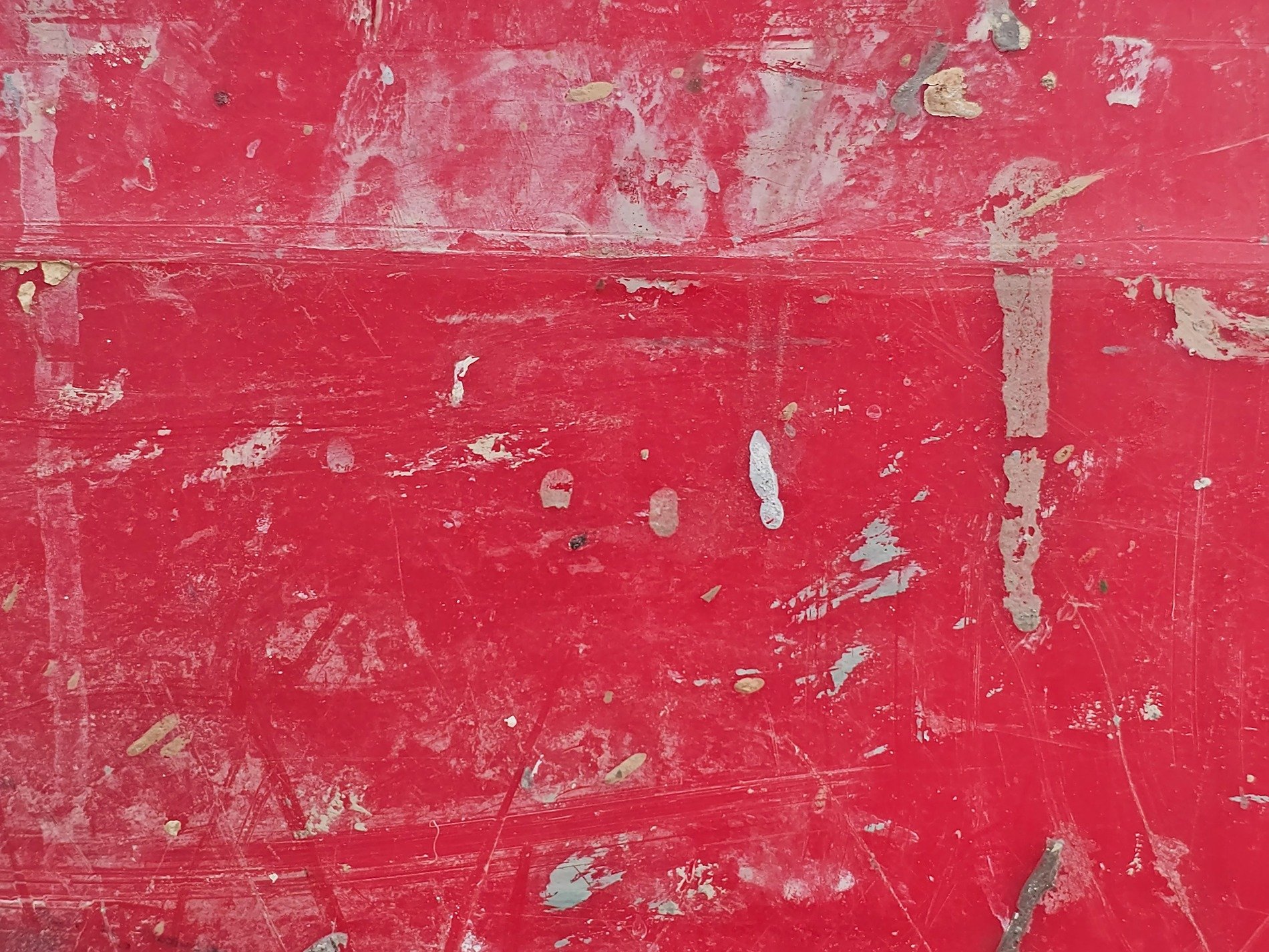 Crimson paint is scarred, white marks dance on worn surface, rough story unfolds
