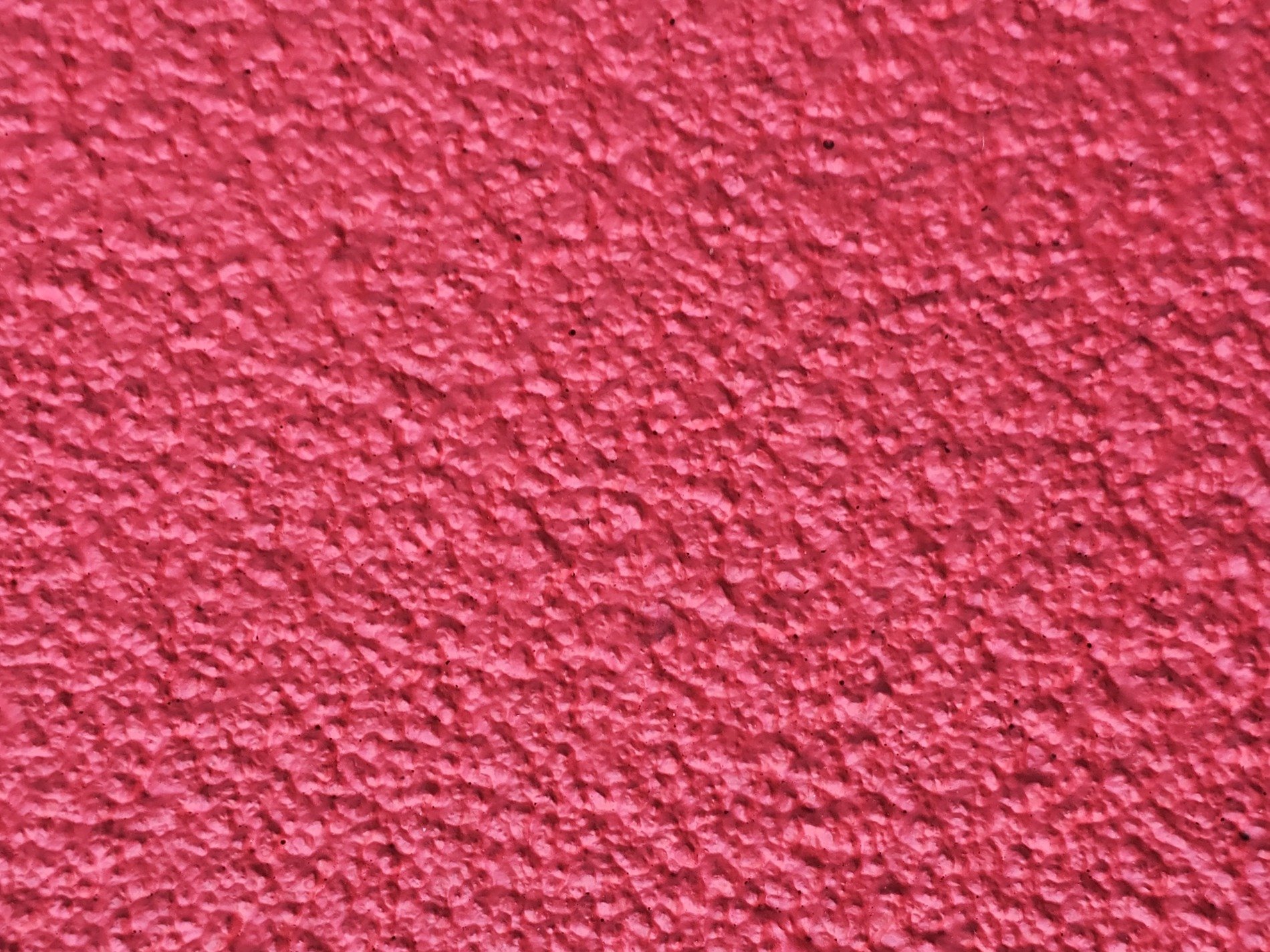 Crimson peaks arise, rough shadows dance on the wall, textured pink surface