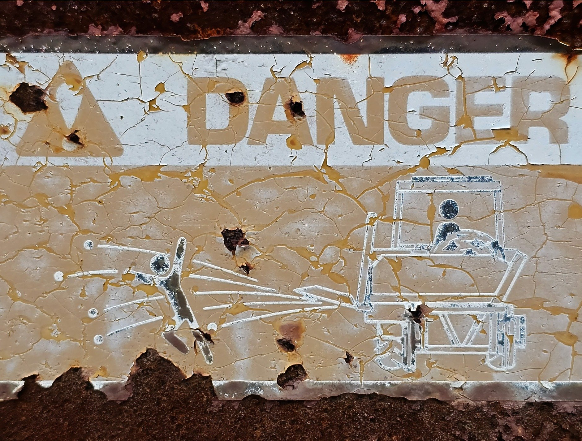 Danger warnings fade away, cracked paint meets the heavy rust, grit marks the finish