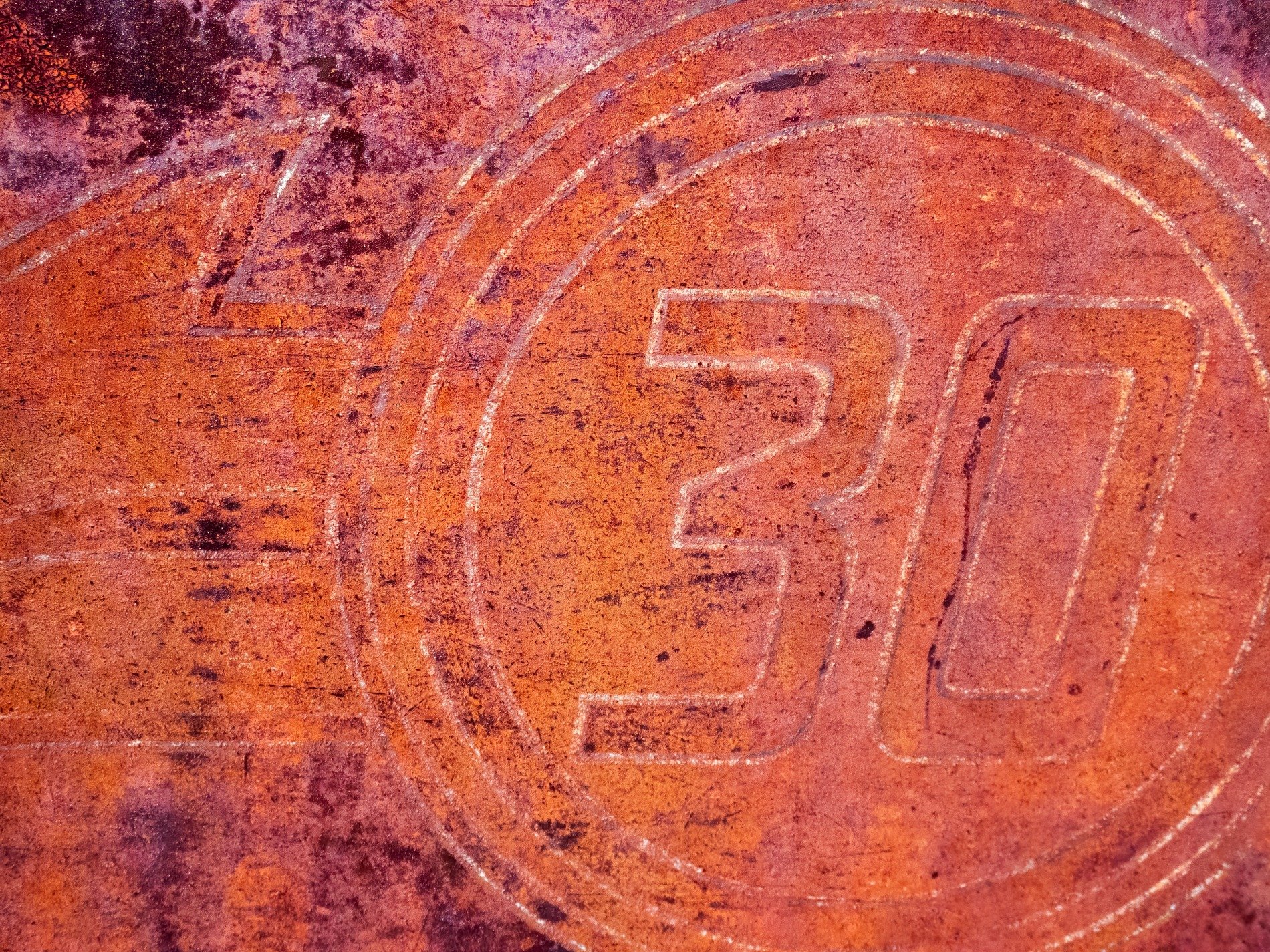 Red iron decays, thirty etched in circles deep, shadows stain the grit