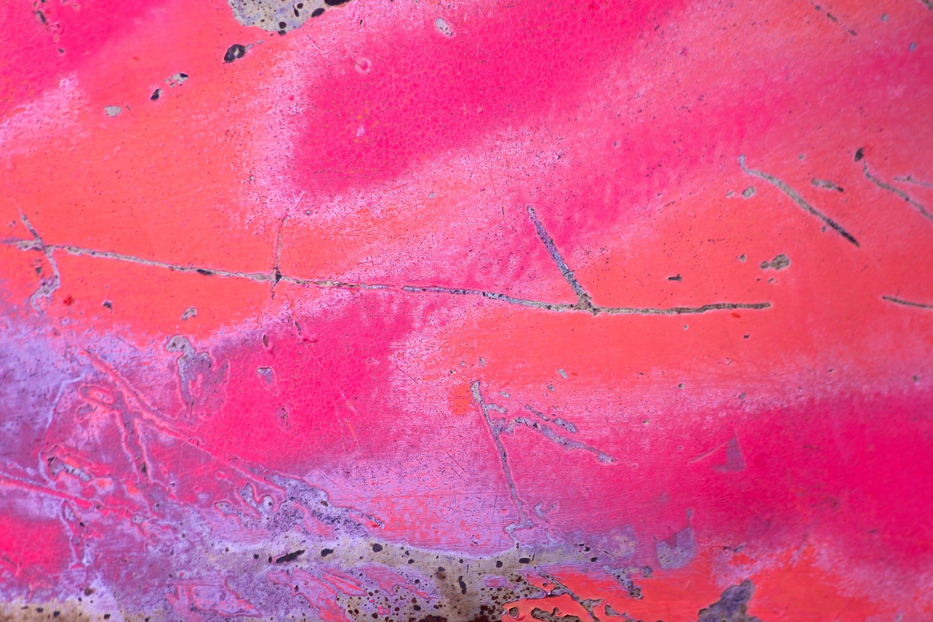 Dark grains flow through deep, jagged scars trace the surface, grit holds the pattern