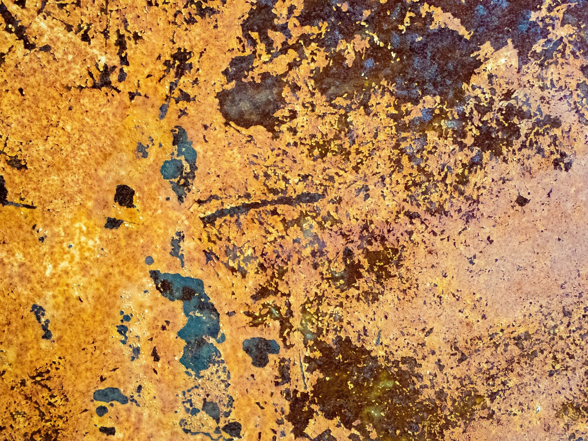 Gold skin flakes away, dark pits mark the heavy core, grit claims the surface