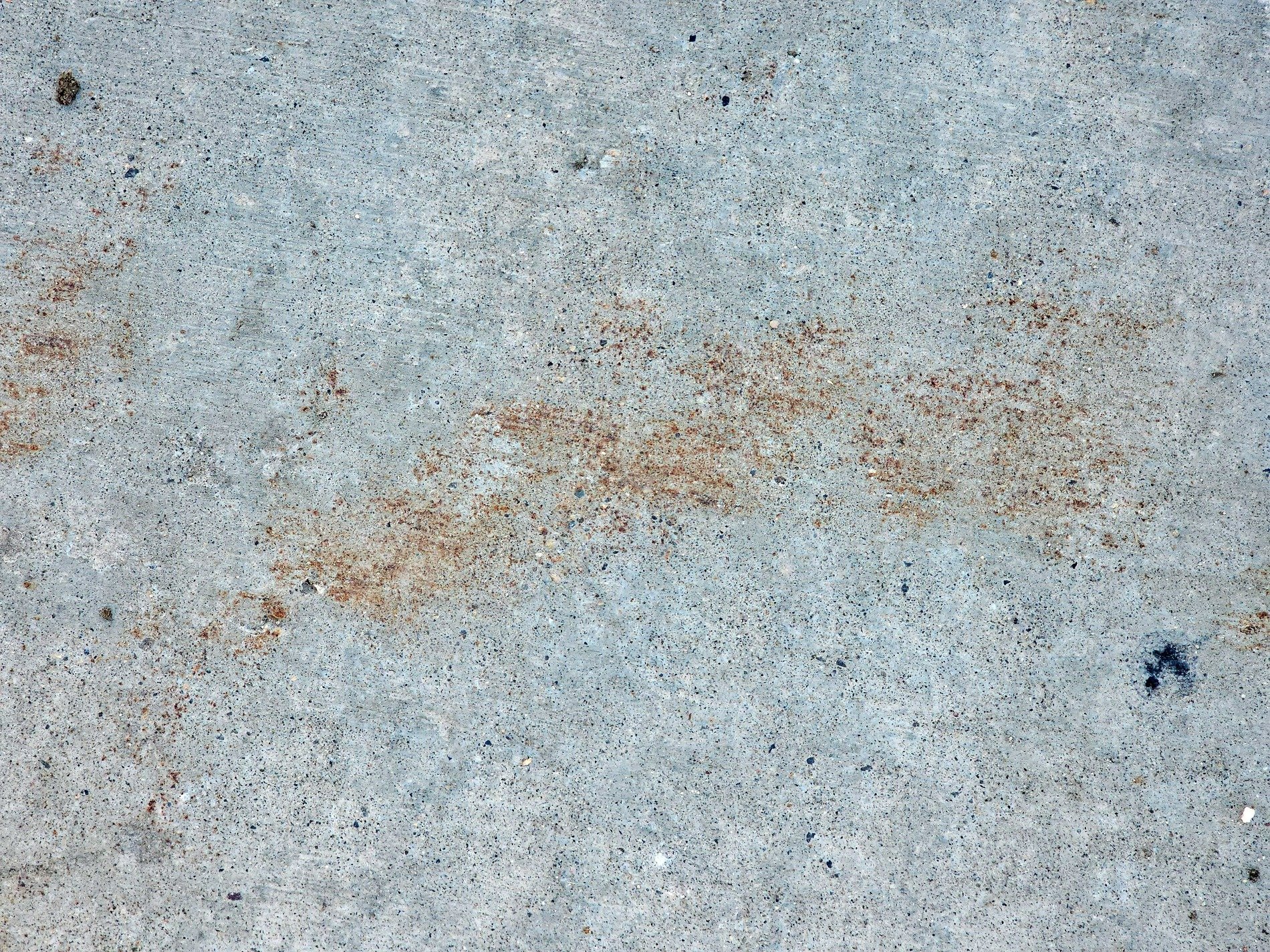 Gray slab holds its ground, rust drifts like a desert cloud, cold stone keeps the mark