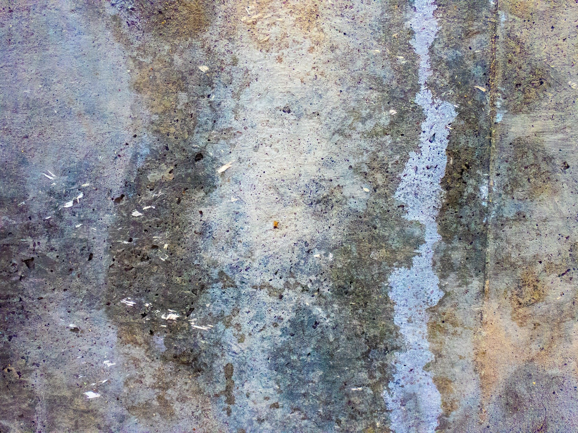 Gray stone holds the stain, blue trails mark the weathered wall, time wears down the stone