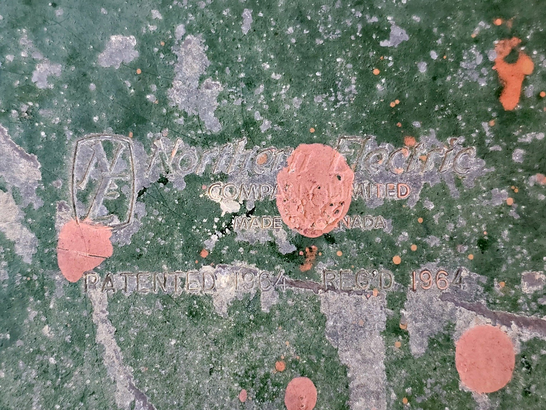 Green paint flakes away, ancient marks of industry, sixty years of wear