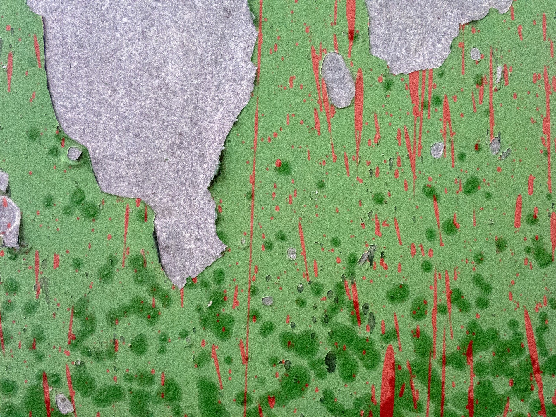 Green skin curls away, red splatters bleed down the wall, grey stone waits behind