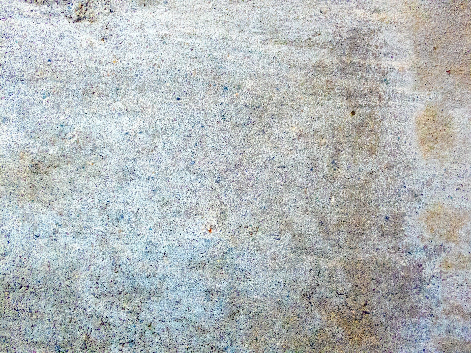 Grey grains of concrete, blue shadows seep through stone, yellow stains of time