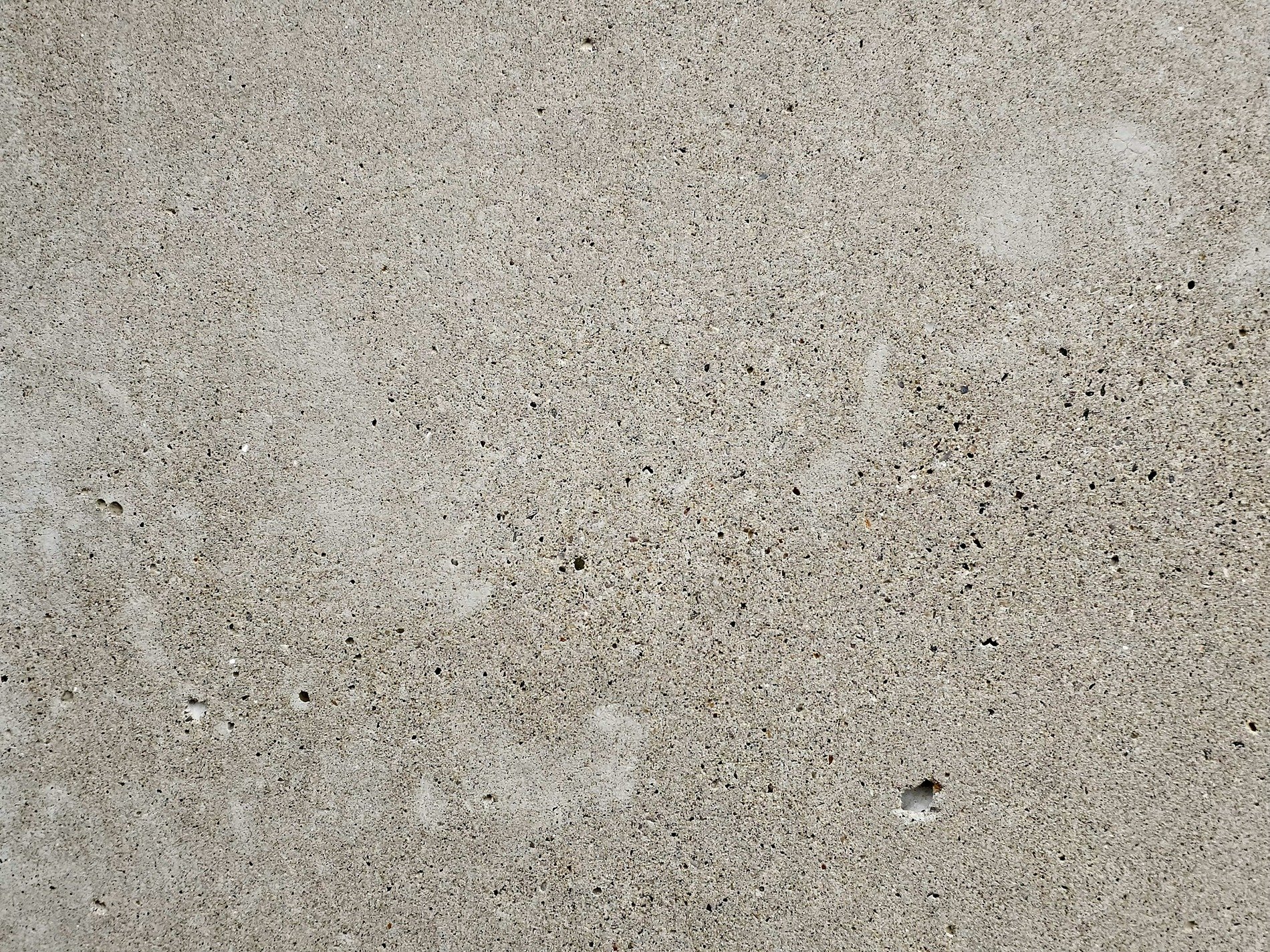 Grey stone holds its form, tiny pits mark out the space, cold and solid wall