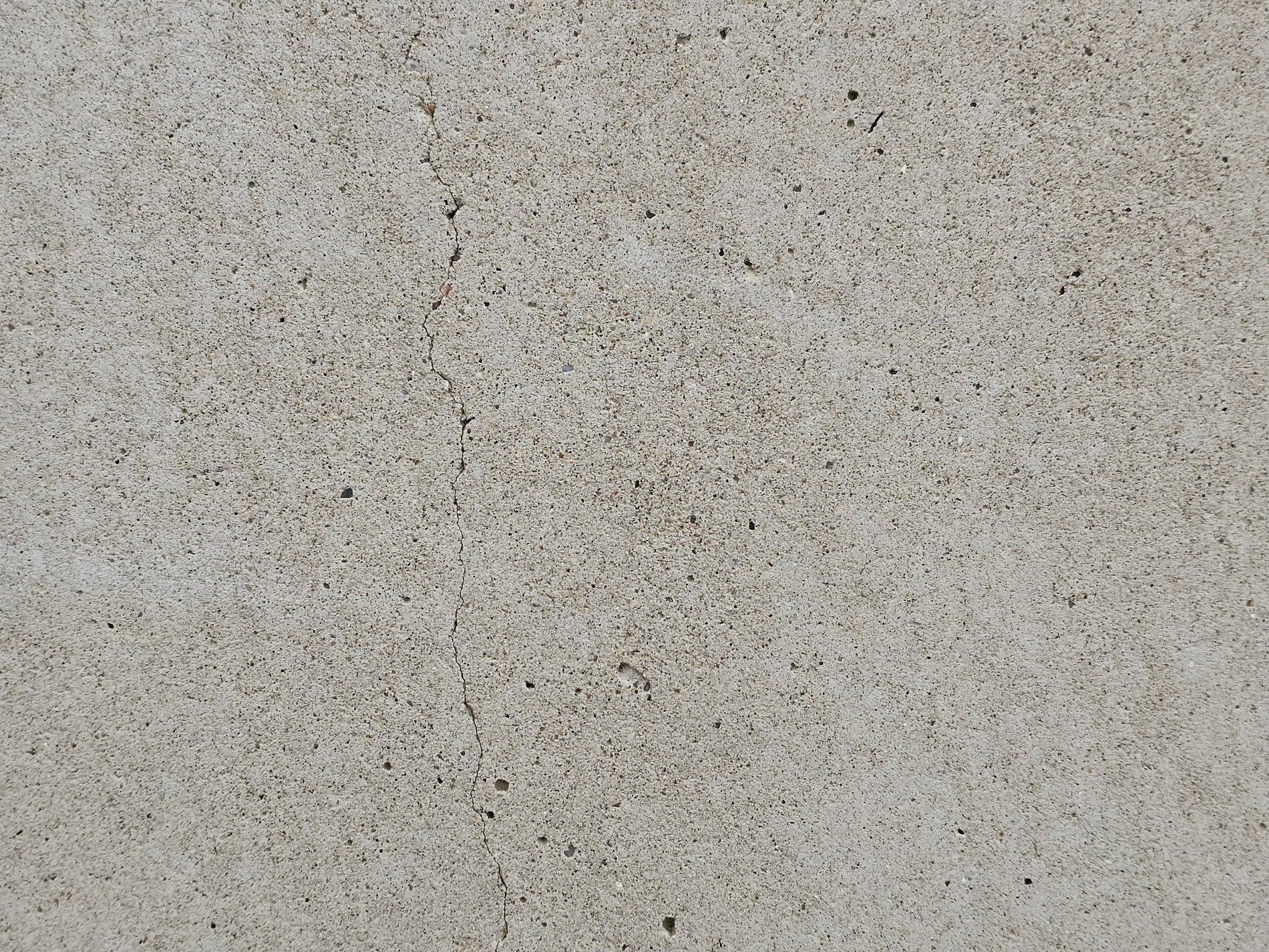 Grey wall is quiet, jagged line cuts through the face, silent stress remains