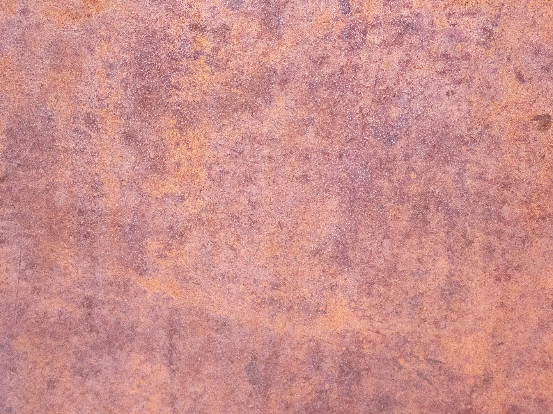 Iron turns to dust, orange blooms on heavy steel, time consumes the plate