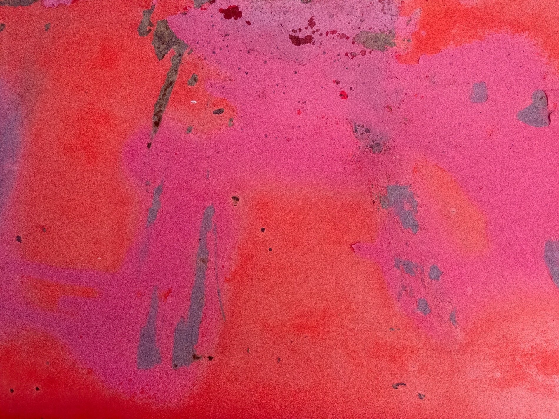 Layers of red paint, pink stains spread across the steel, iron starts to show