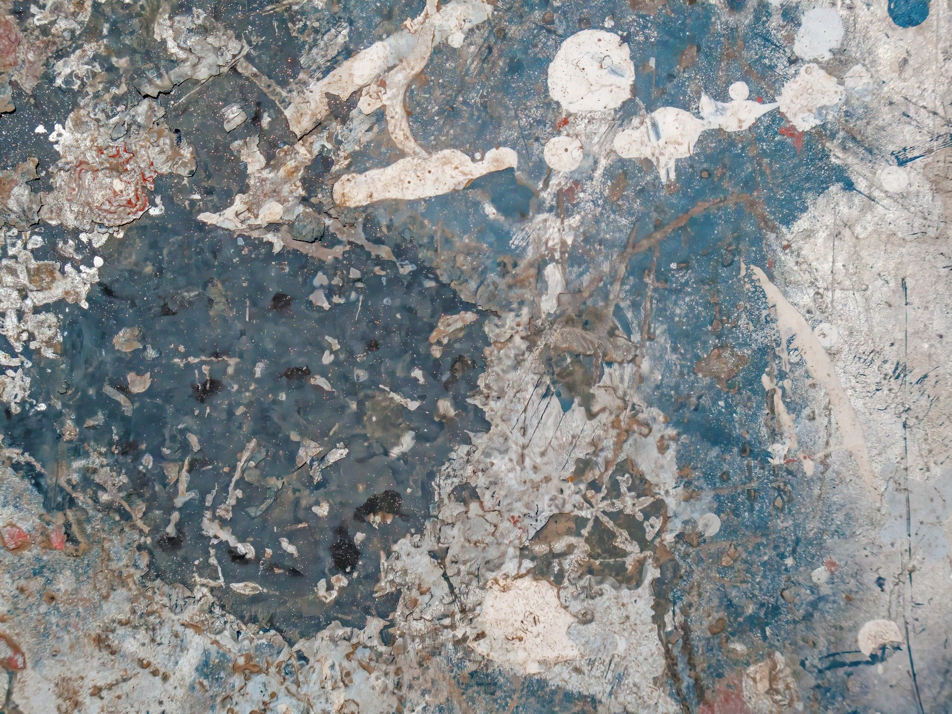 Layers peel away, white spills on a field of blue, concrete shows its scars