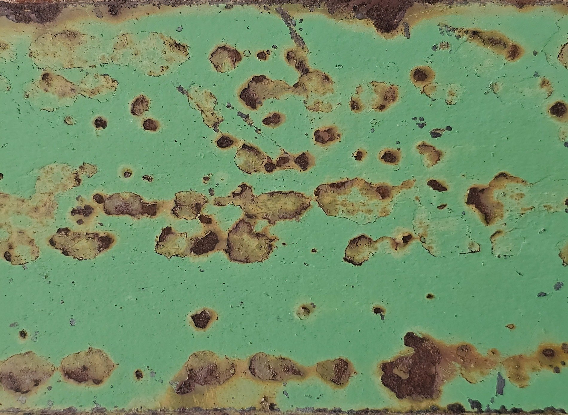 Mint paint wears away, orange rust spots bloom like clouds, metal meets the air