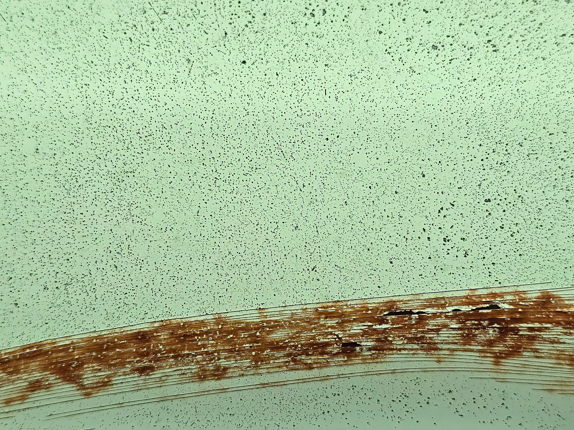 Mint paint wears away, jagged rust cuts through the field, metal starts to bleed