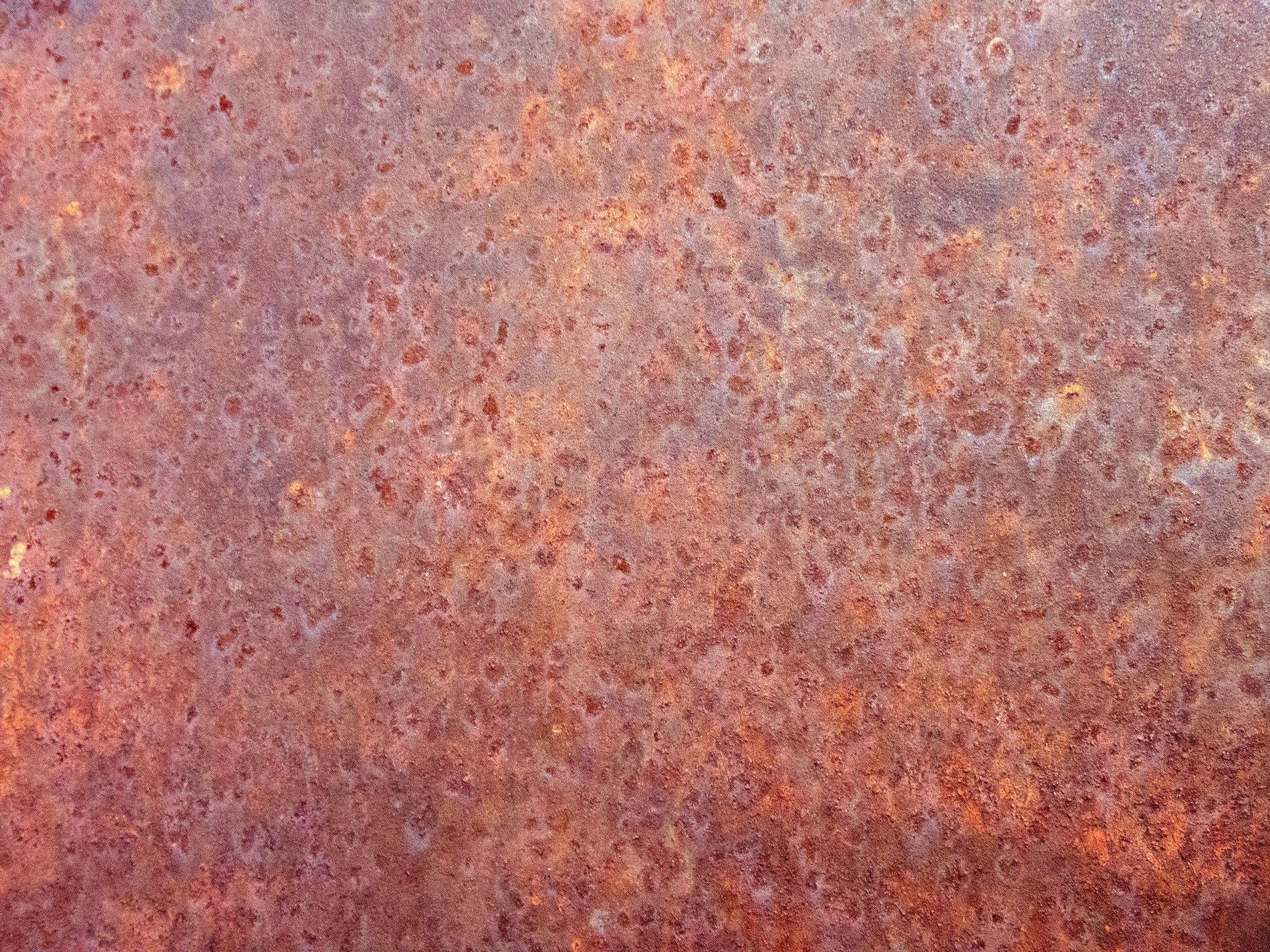 Orange dust on iron, oxidation blooms in heat, time eats through the steel