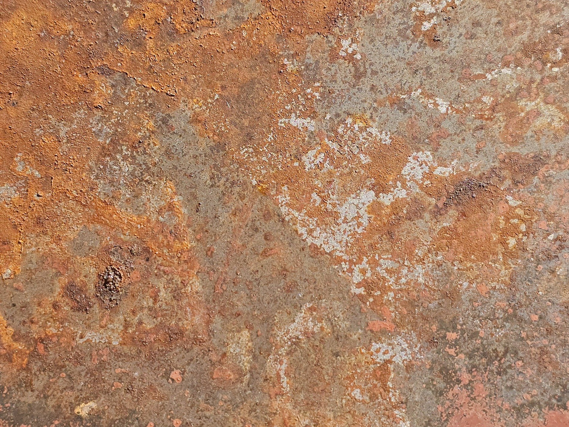 Orange fields meet grey, jagged rust traces paths, light holds the pattern