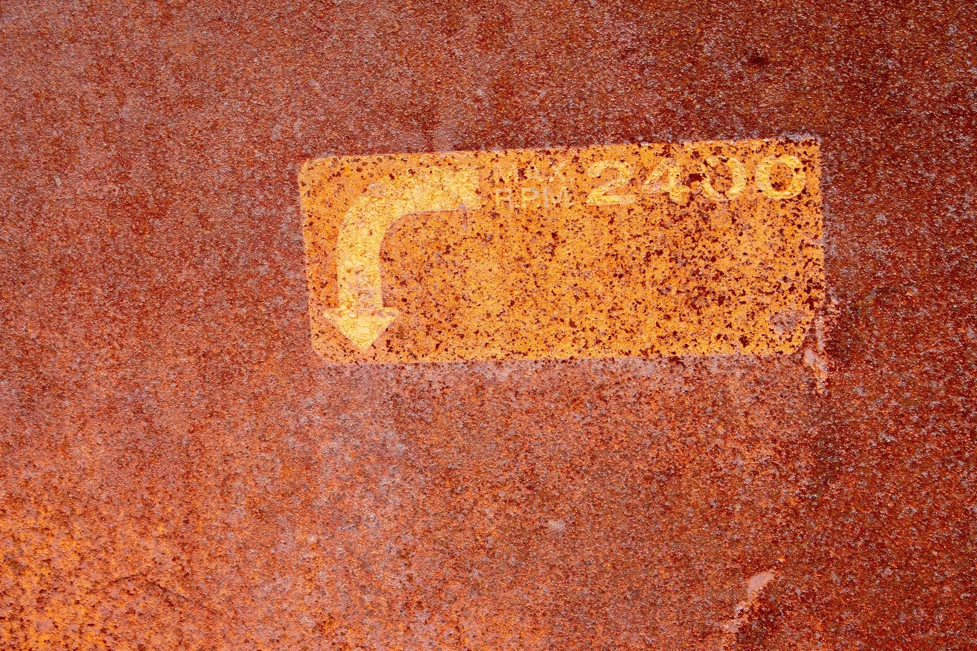 Orange grit claims speed, heavy paths trace the surface, light carves the metal