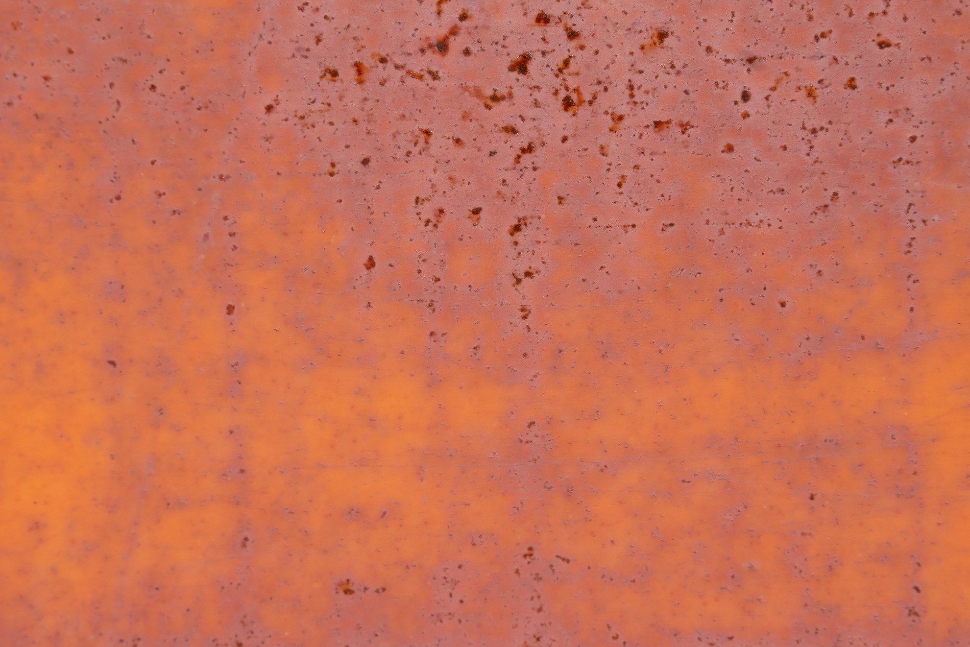 Orange iron fades, dark rust blooms across the surface, metal yields to time