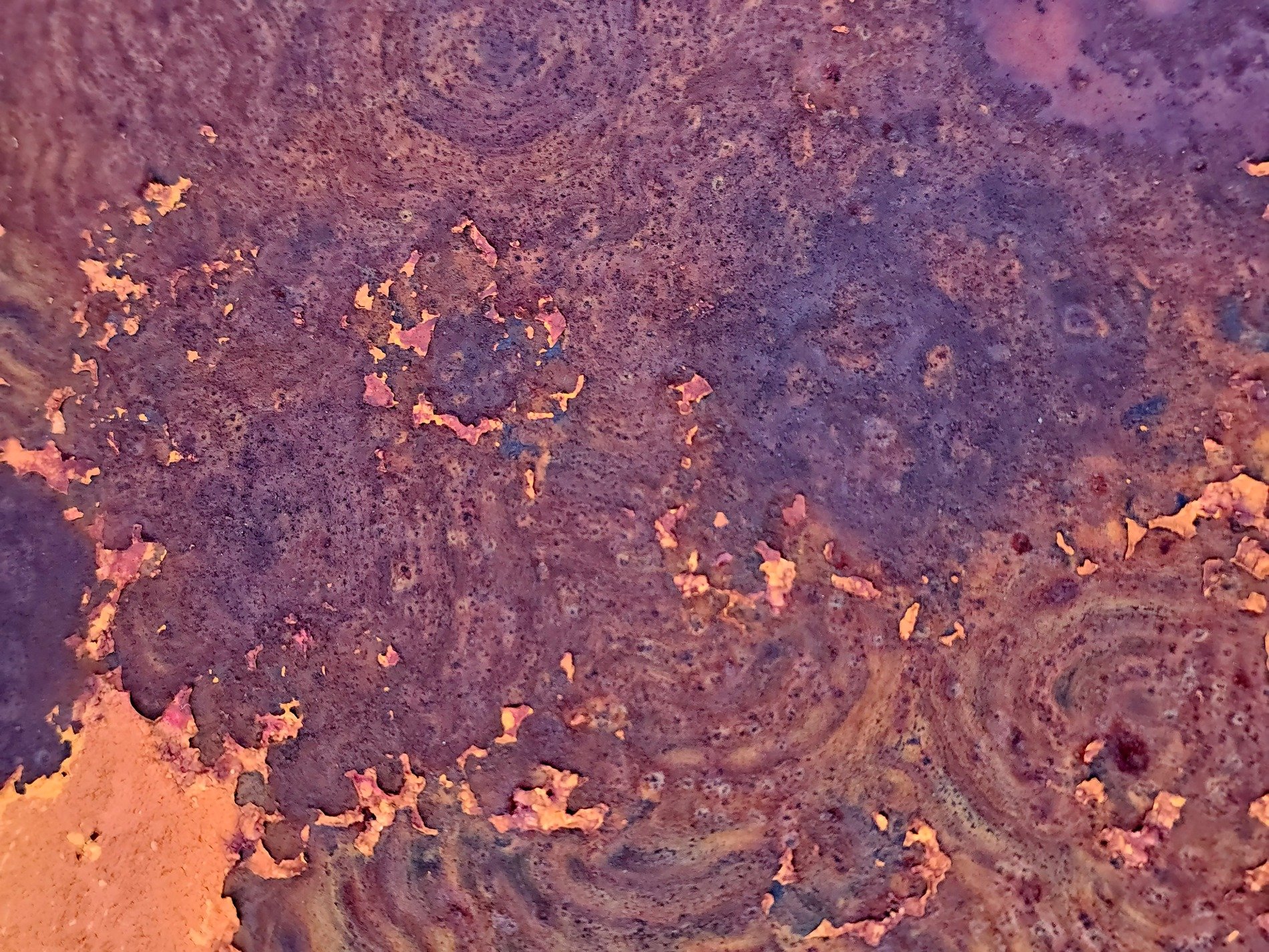 Orange paint flakes off, iron swirls in circles now, rust claims every inch