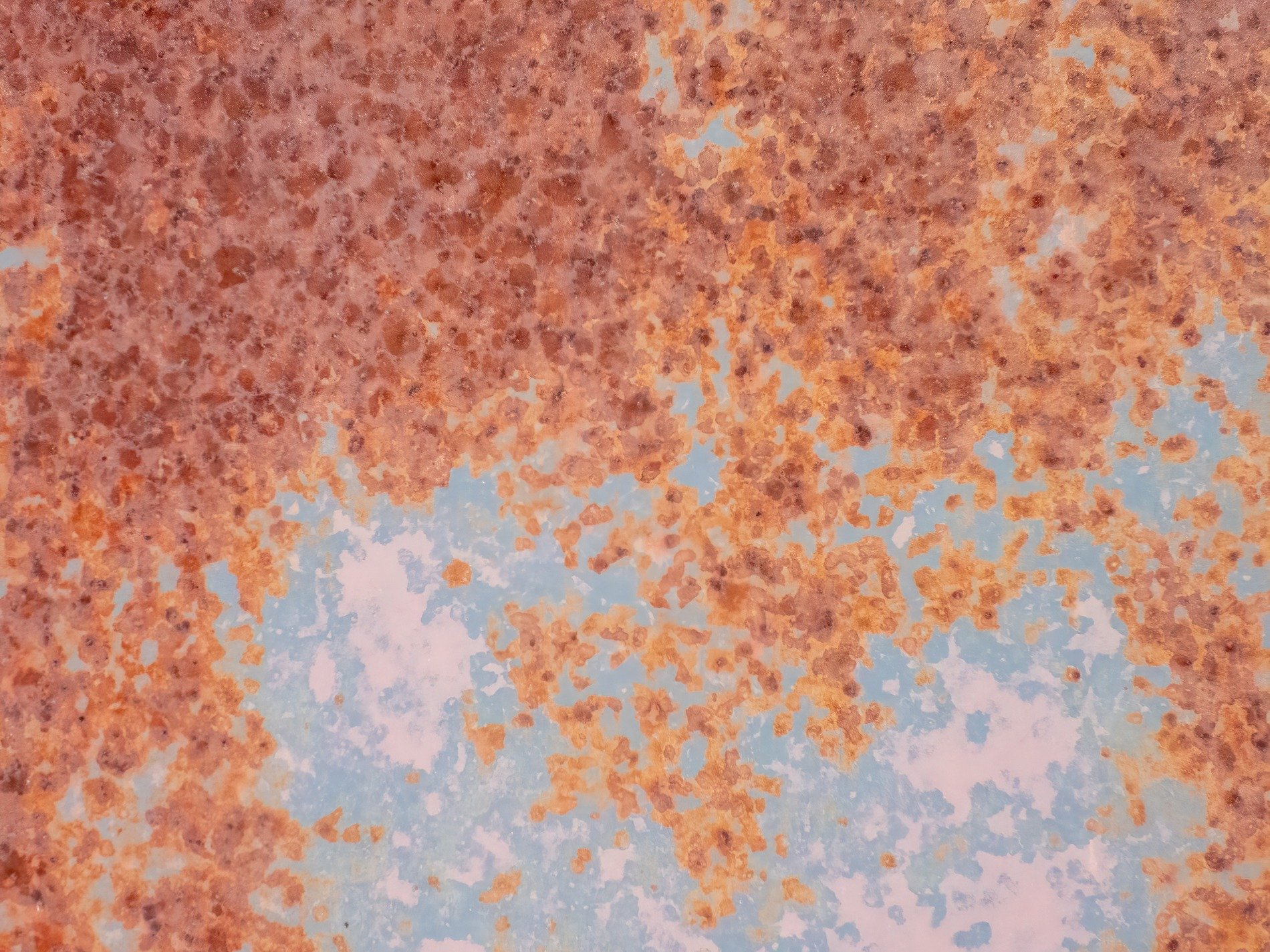 Orange rust spreads out, blue paint fades in decay, metal turns to dust