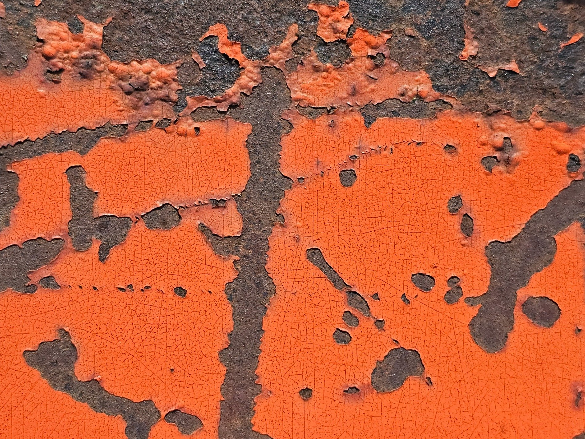 Orange skin peels back, iron yields to deep brown rust, cracked lines form a map